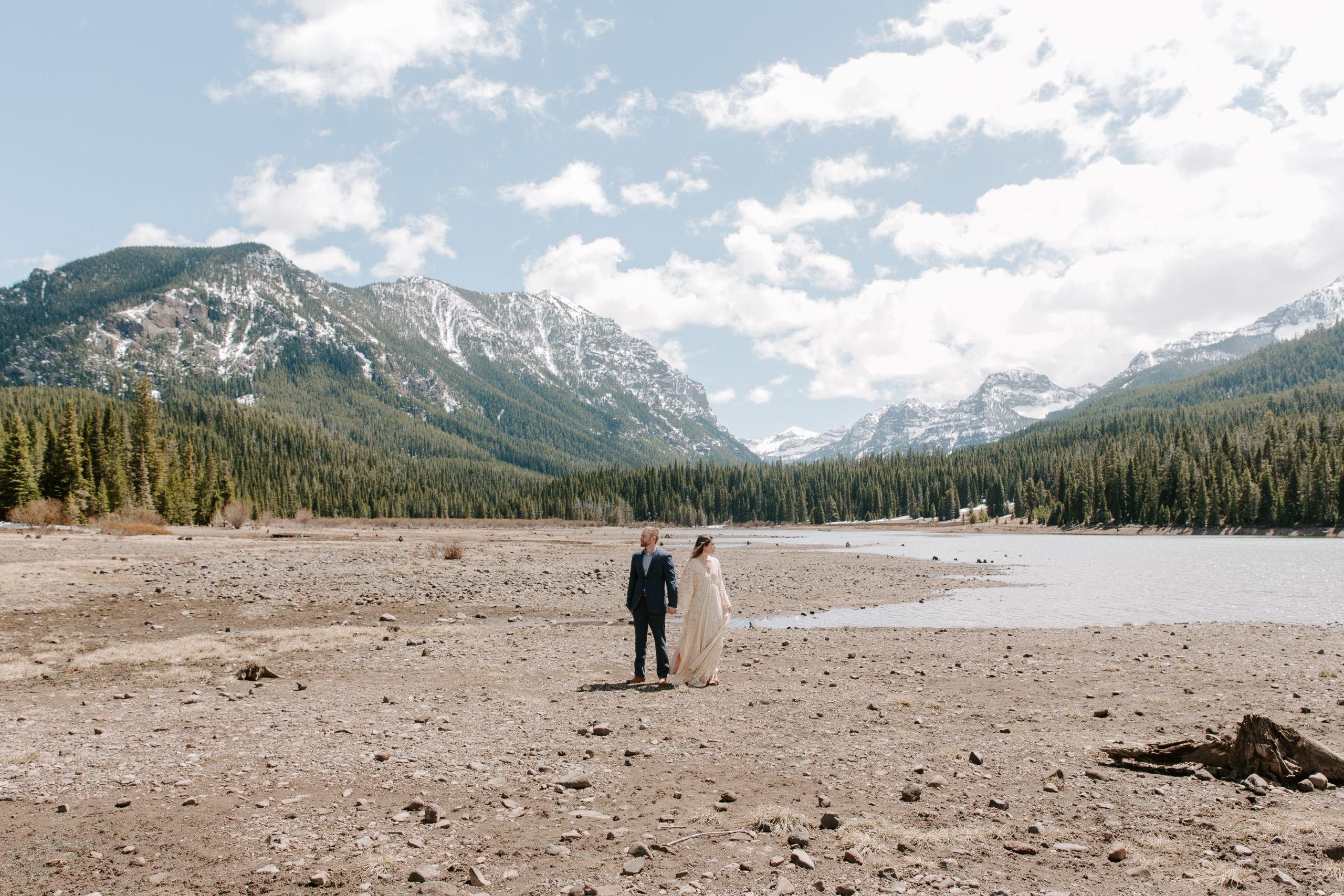 Couple standing in the middle of a dry lake bed in Bozeman, Montana during their all day adventurous elopement