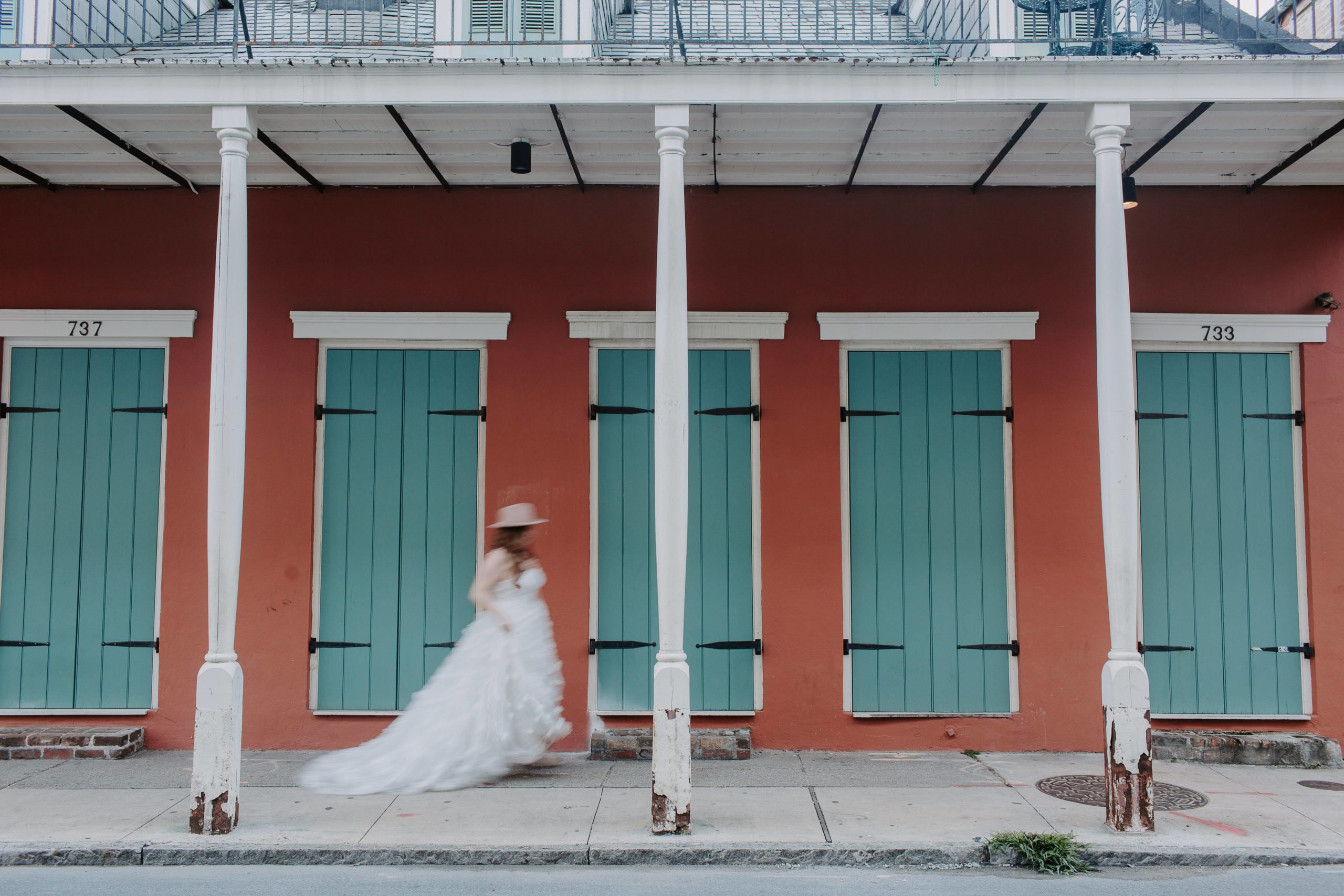 Woman running in a wedding dress through the streets of New Orleans during her French Quarter elopement