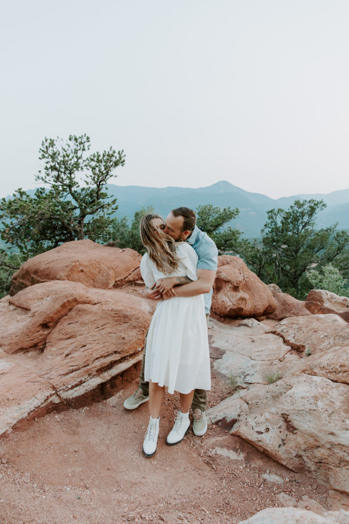 Man holding his partner from behind as they are swaying with her hair blowing in the wind during their Colorado adventure couple session