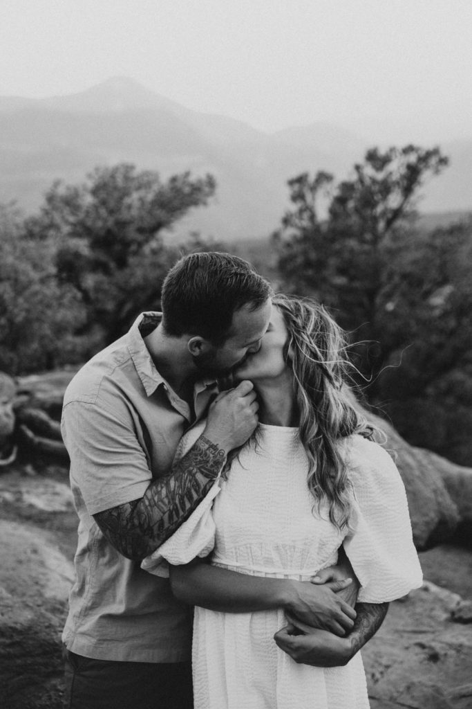 Man holding his partners chin while he brings her in for a kiss during their Colorado Springs couple session