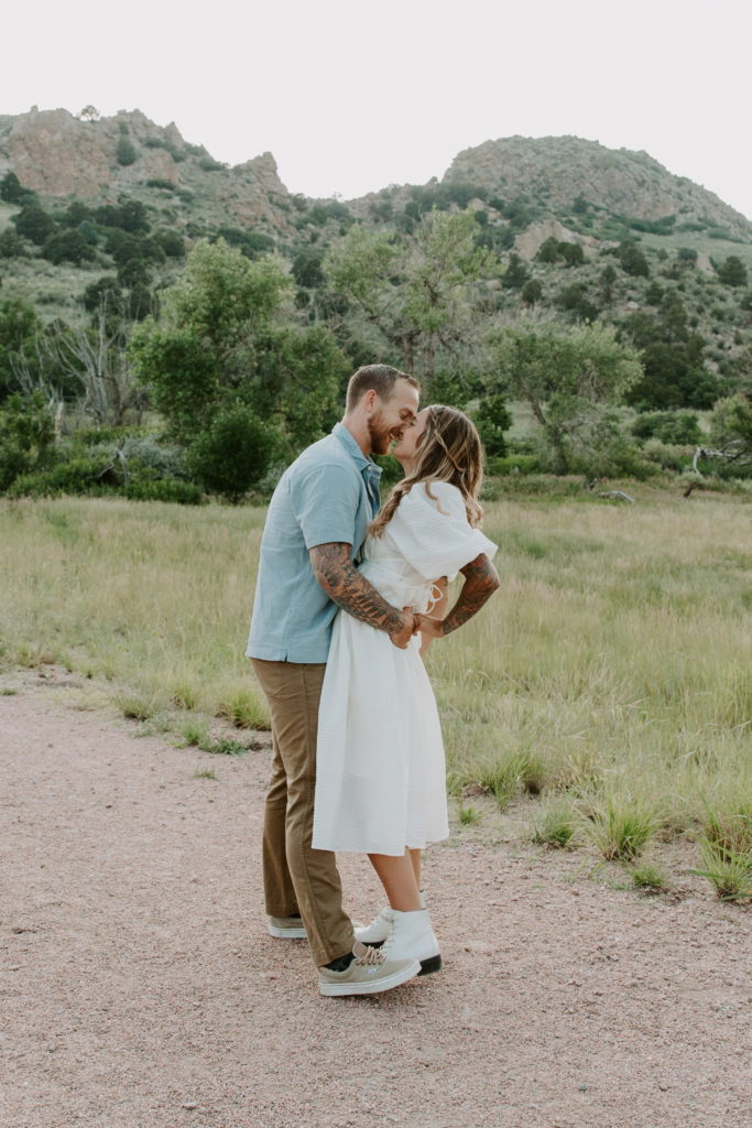 A man has his hands on his partners hips as he is bringing her in for a kiss and dipping her back a little during their Colorado couples session