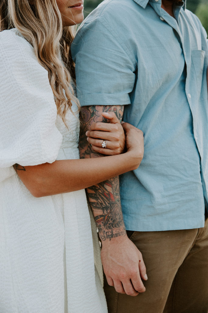 Up close image of a woman holding her partners arm where you can see her engagement during their Colorado engagement photos