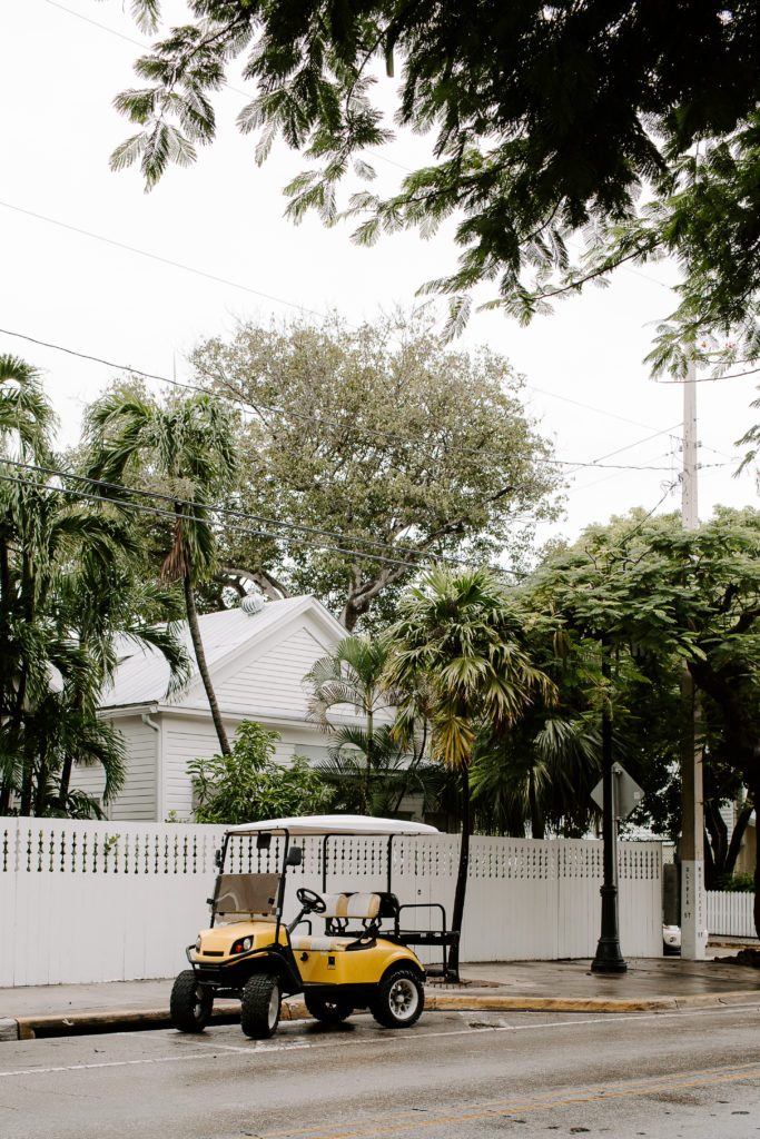 Yellow golf cart sitting on the side of the road during a couples all day key west elopement