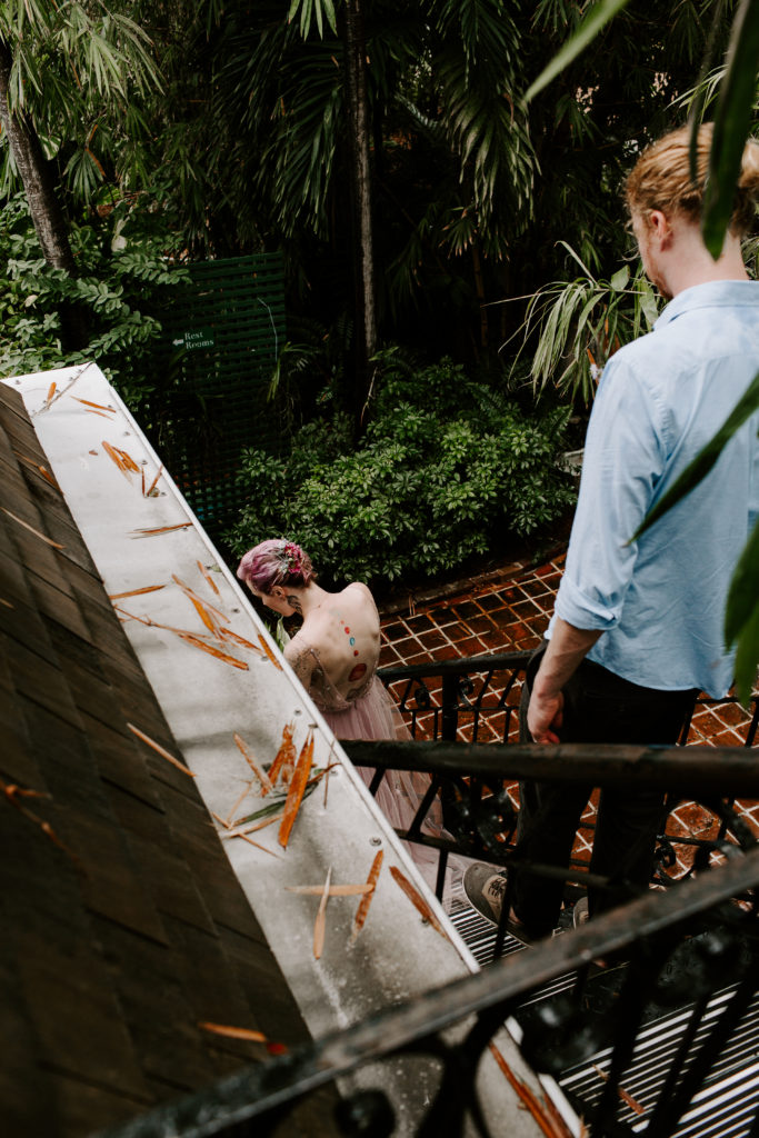 couple walking down a set of stairs at the hemingway house before they have their wedding ceremony