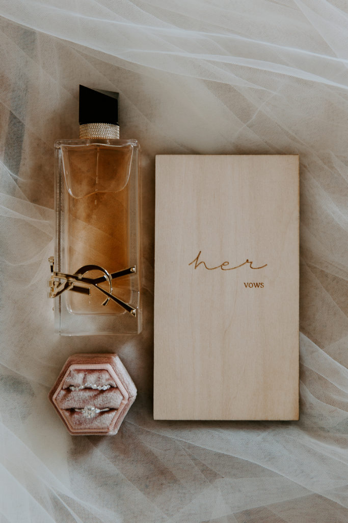 Her vow book, wedding bands and perfume sitting atop her veil