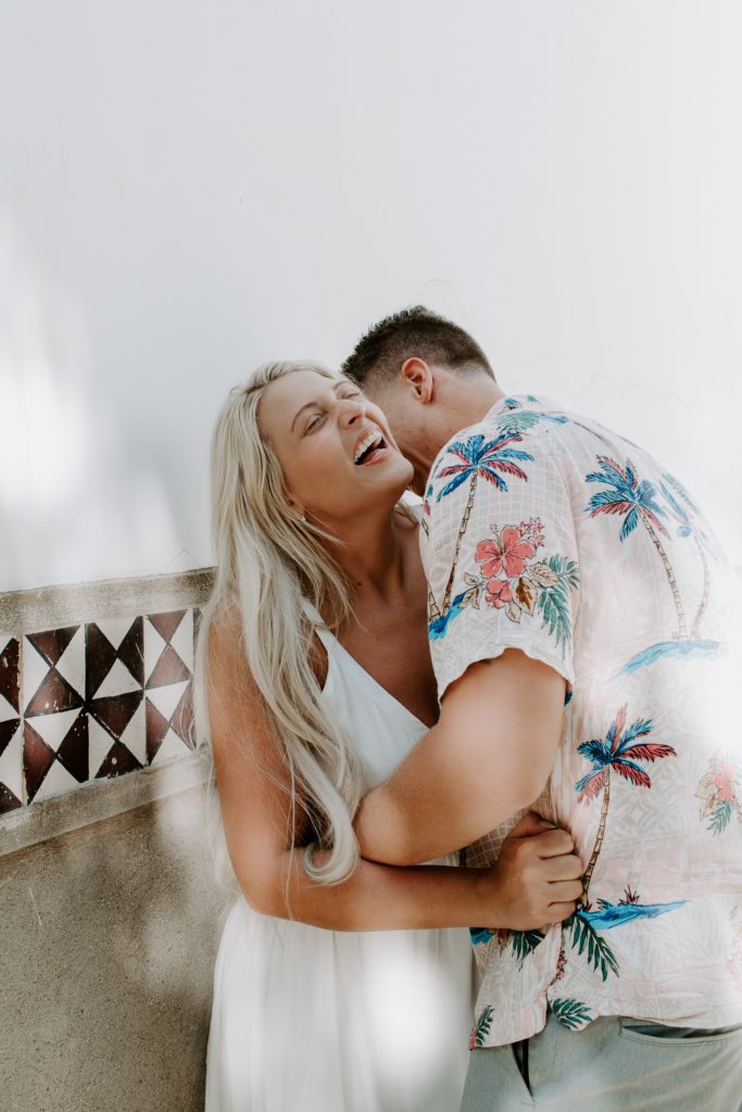 Woman laughing as her partner wraps his arms around her during their Capri elopement