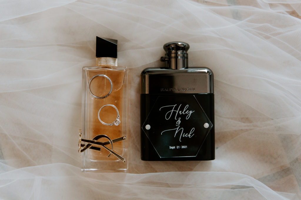 Wedding day details with perfume, and wedding rings