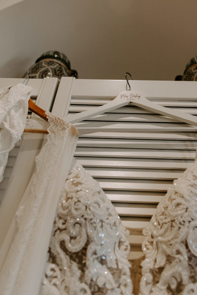 Lace wedding dress and lace lingerie hanging up prior to the women putting it on for her wedding day