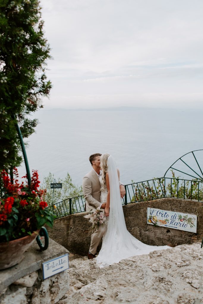 Couple sneaking a kiss before their Italian elopement