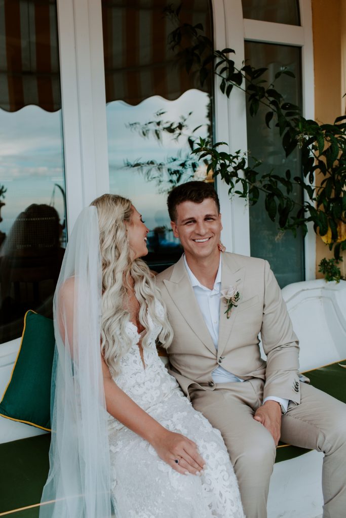 Man laughing as his new wife whispers in his ear during their Italian Elopement