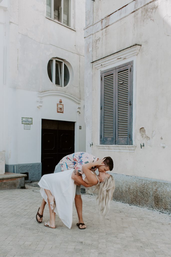 Man dipping and kissing his parter on a street in Anacapri, Italy