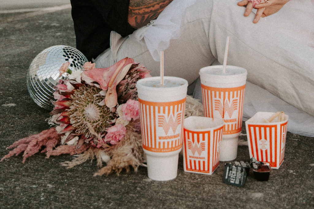 Whataburger sitting on the ground next to a big wedding bouquet during a couples Alabama elopement