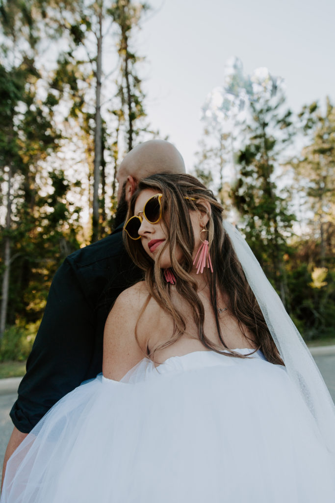 Woman wearing yellow sunglasses looking off into the distance after their Alabama wedding ceremony