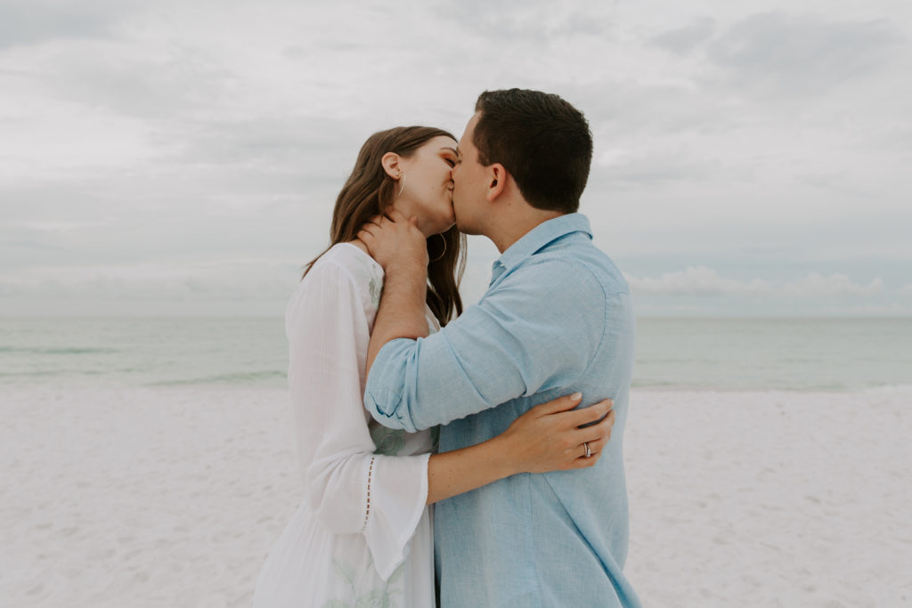 A couple sharing a kiss in the early morning with their arms wrapped around each other during their Florida engagement photos