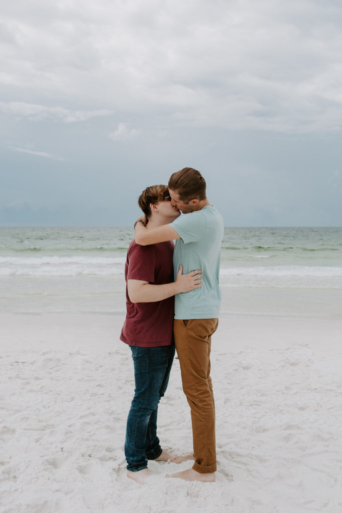 Couple sharing a kiss on the beach in the early morning