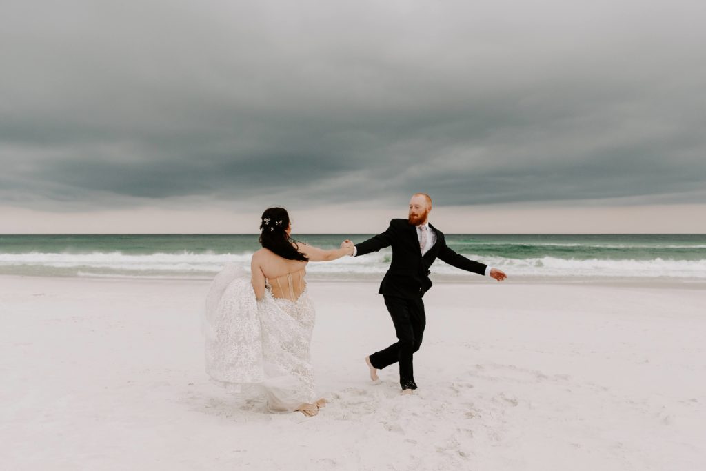 Couple spinning in circles on the beach during their sunset beach elopement in Destin, Florida