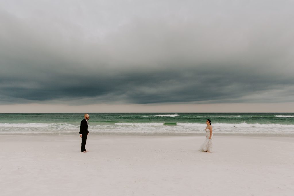 Man and woman walking towards each other dramatically during their beach vow renewal in the Florida panhandle