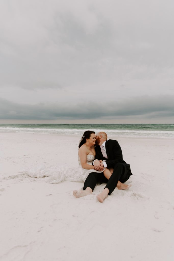 Couple sitting on the beach with the storm coming in behind them