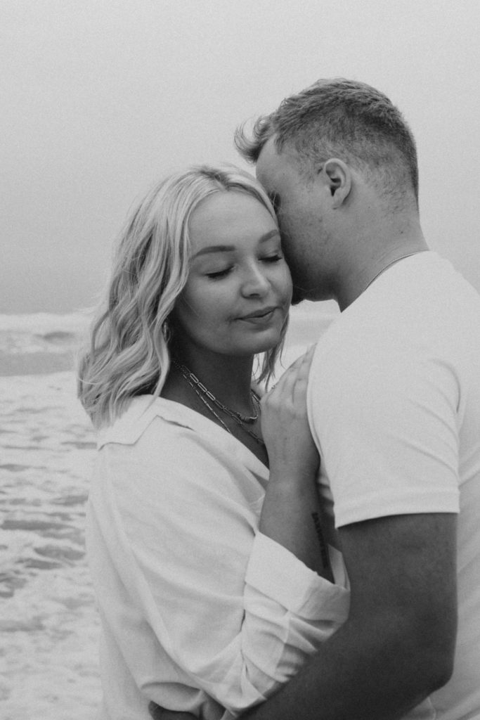 Couple standing close to each other and resting their heads together with their eyes closed during their Florida couple photoshoot