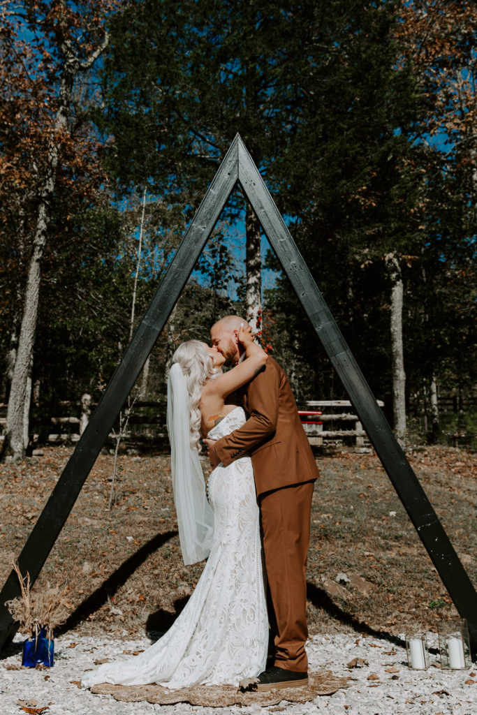 A couple sharing their first kiss during their Arkansas elopement in the Ozarks