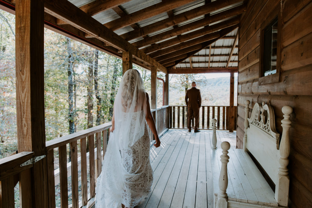 A woman walking down the side porch of the cabin during their Ozarks elopement