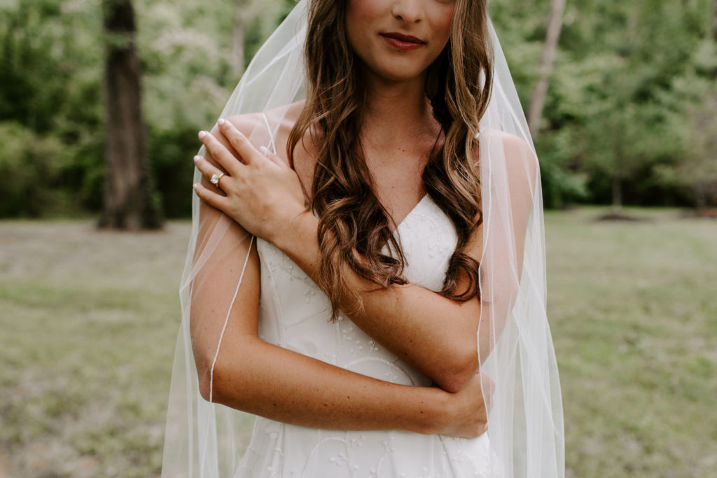 A bride wrapping herself in her arms during portraits on her wedding day in Tennessee