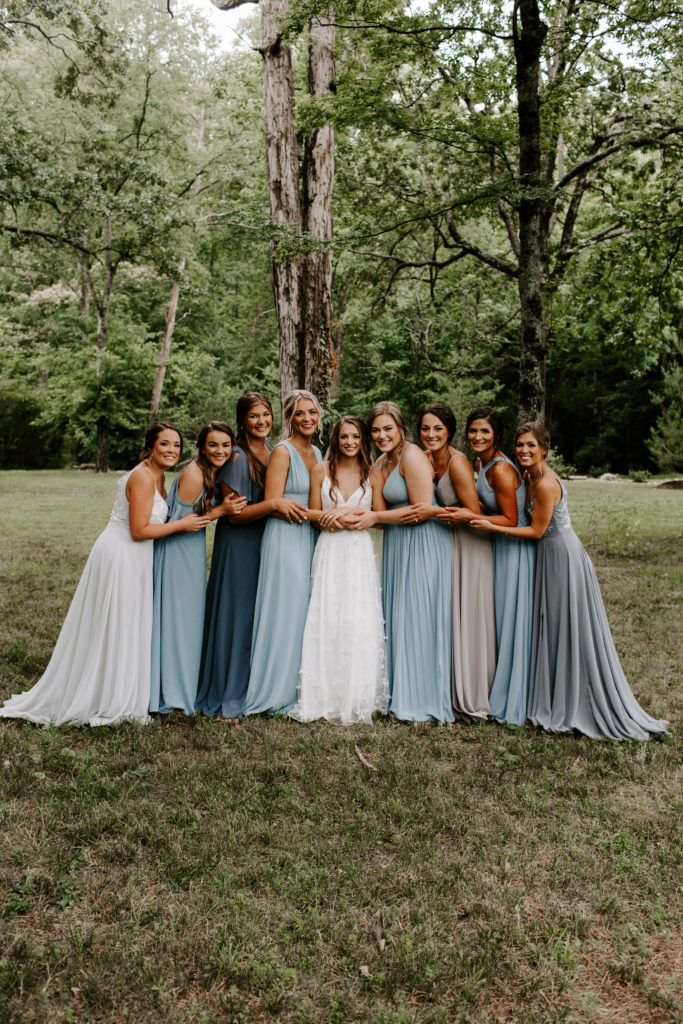 A bride and her bridesmaids all hugging on each other and smiling during her East Tennessee Wedding