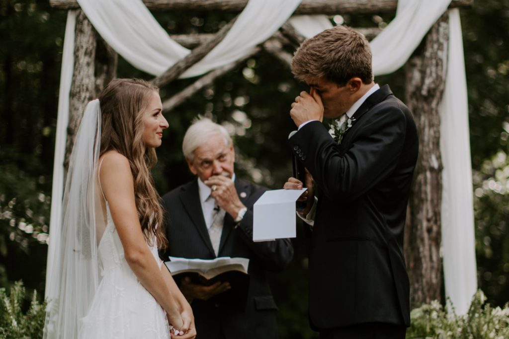 The groom whipping away a tear during the ceremony while he is saying his vows