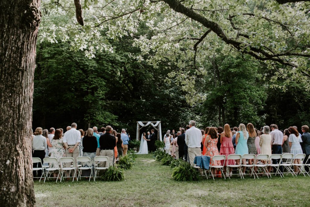 An outdoor wedding ceremony where the couple is standing under an arch in East Tennessee
