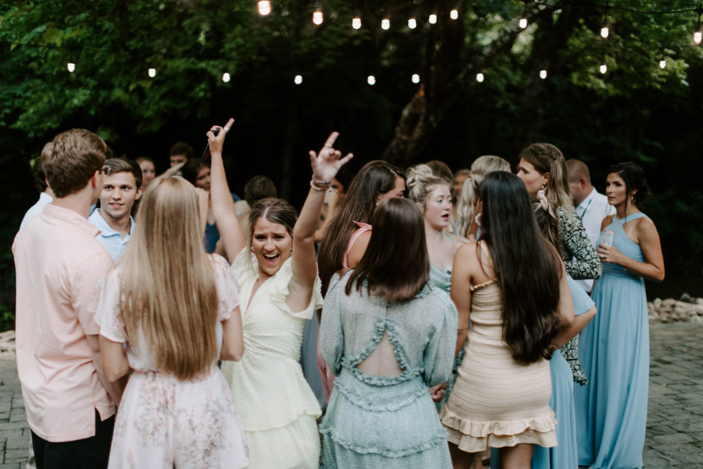 A wedding guest throwing her arms in the air during a knoxville tennessee wedding reception