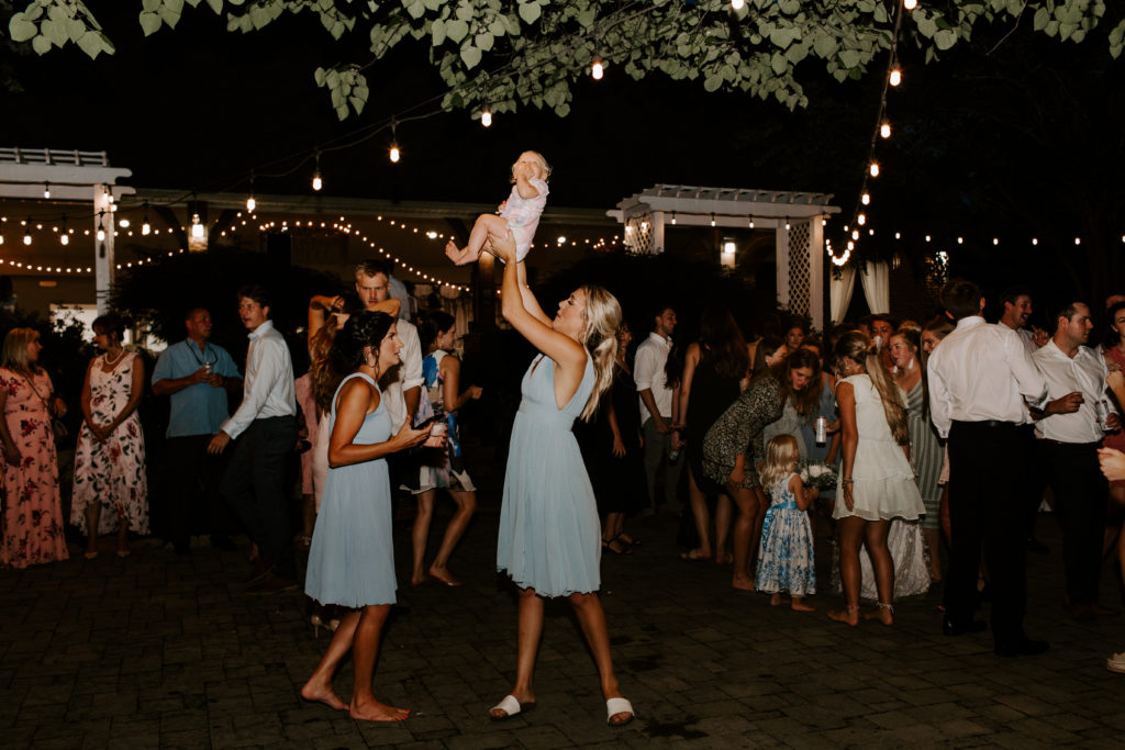 Bridesmaid tossing her niece in the hair during the East Tennessee wedding reception