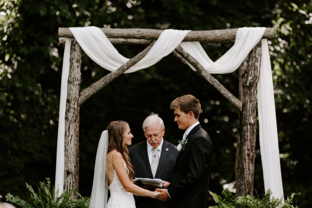 Couple holding hands looking at each other during their outdoor Tennessee wedding
