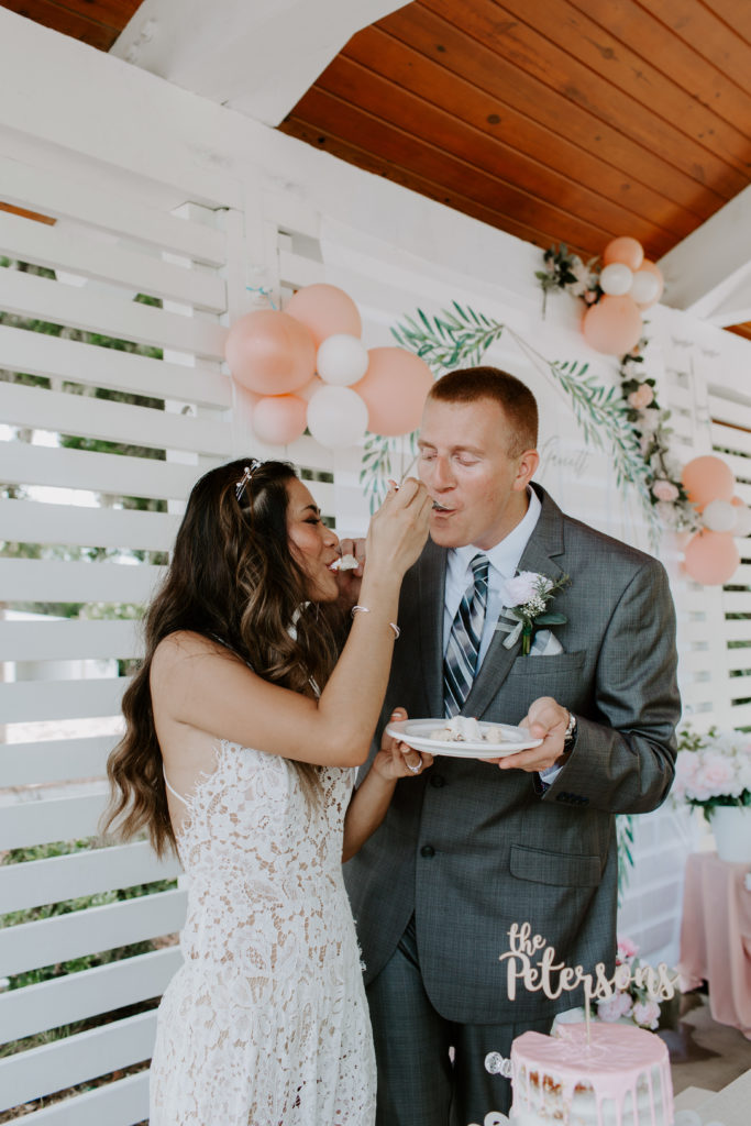 Couple feeding each other cake during their city park elopement in Florida