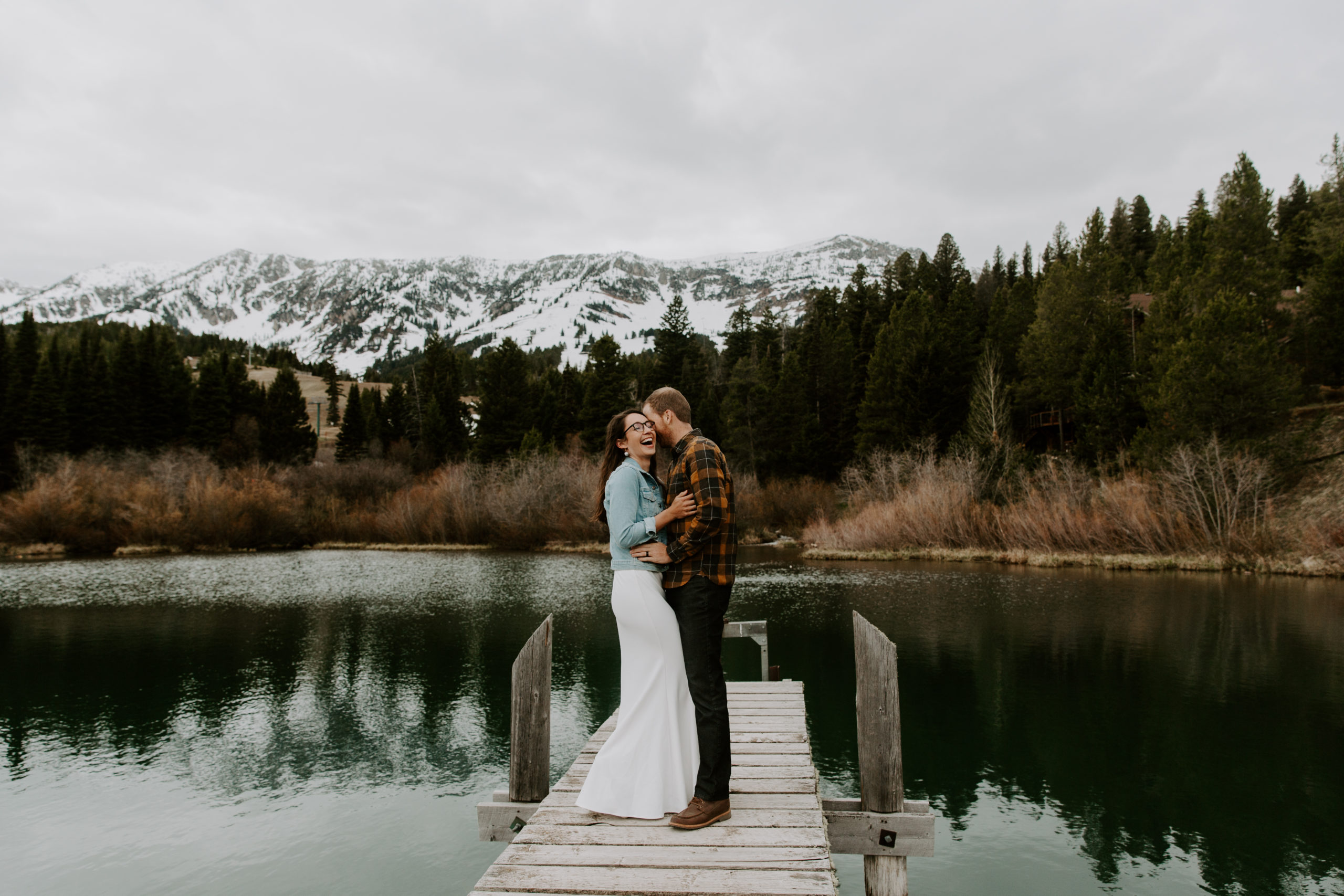 Couple standing on a dock over the lake embracing during their Montana elopement