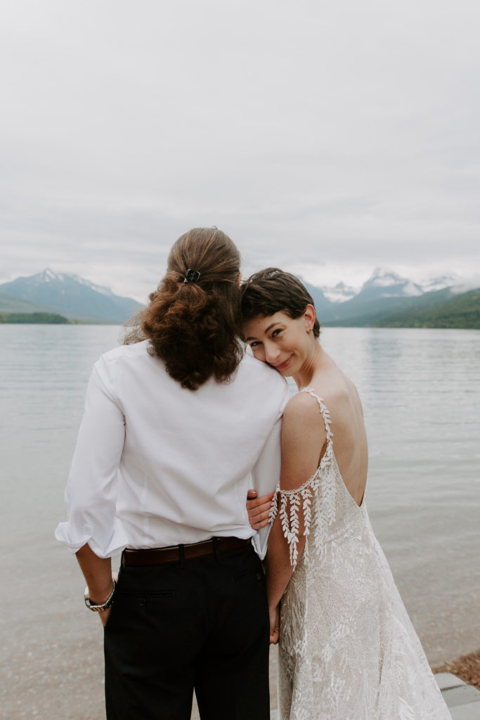 Woman holding onto her partners arm as she looks backwards during their lake jenny elopement