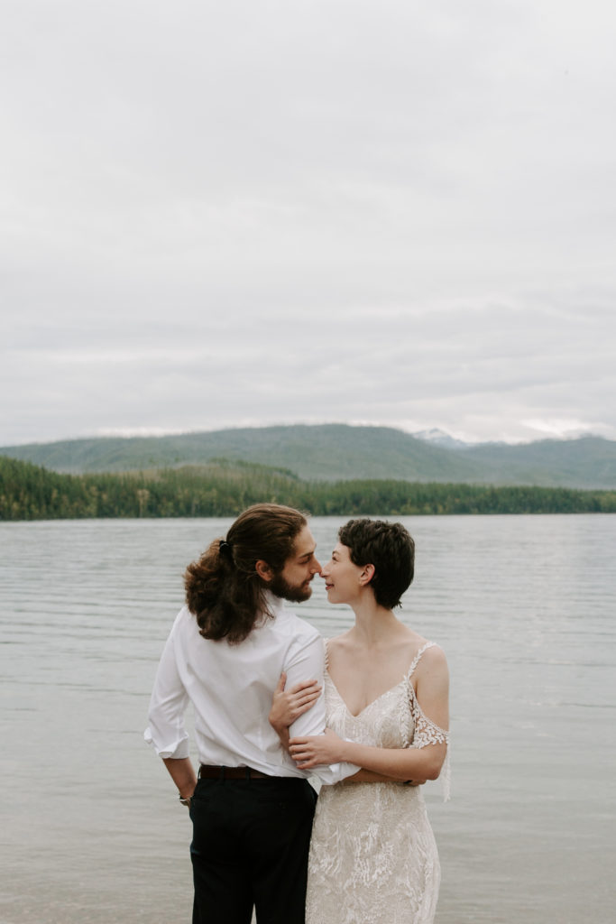 Couple standing on the water about to share a kiss during their glacier national park elopement