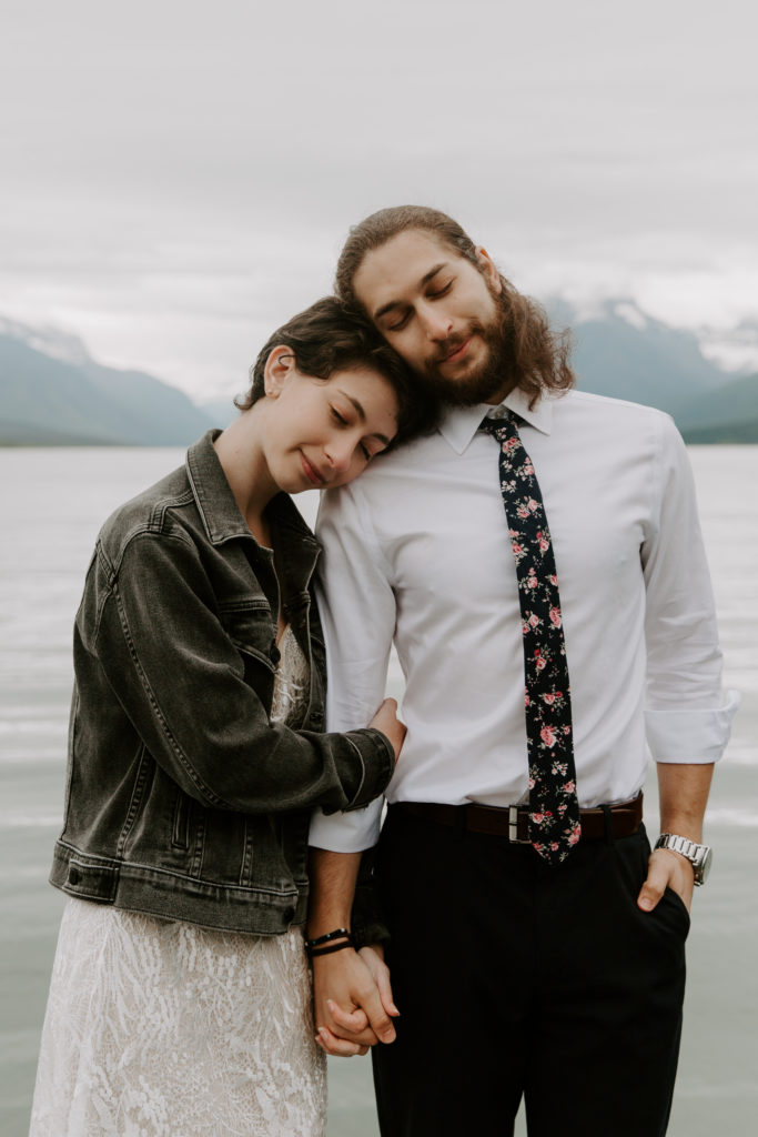 Couple leaning into each other both with their eyes closed during their glacier national park elopement