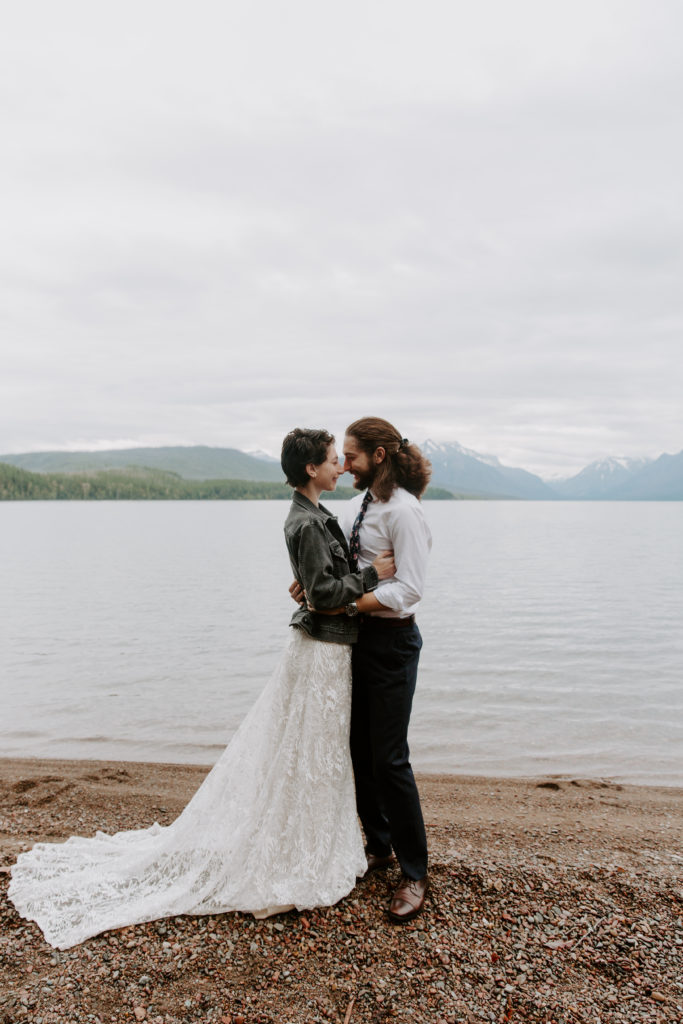 Couple standing facing each other in front of Jenny lake during their mountain elopement
