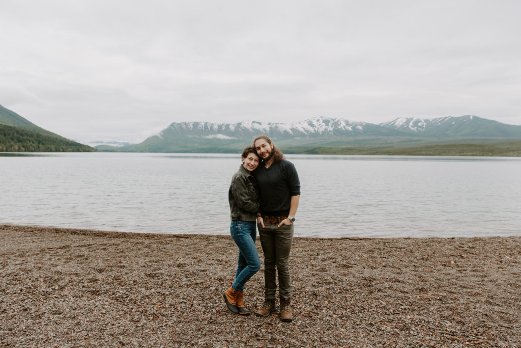 Man and a woman nuzzling into each other with the mountains in the background during their elopement day