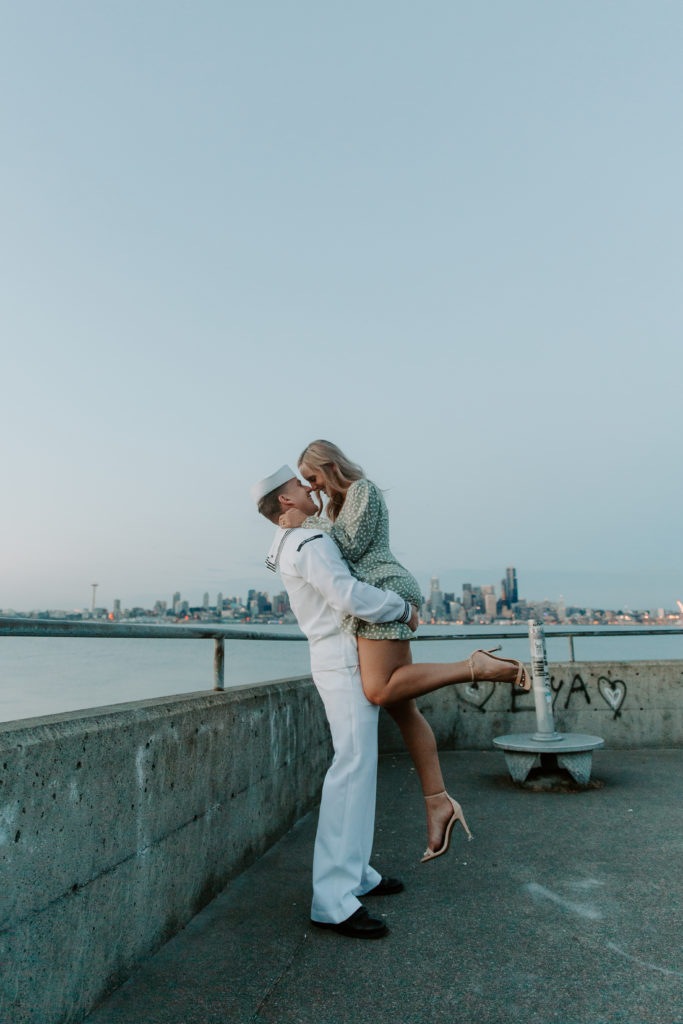 A man picking up his partner and twirling her around while giving her a kiss during their Seattle engagement photos