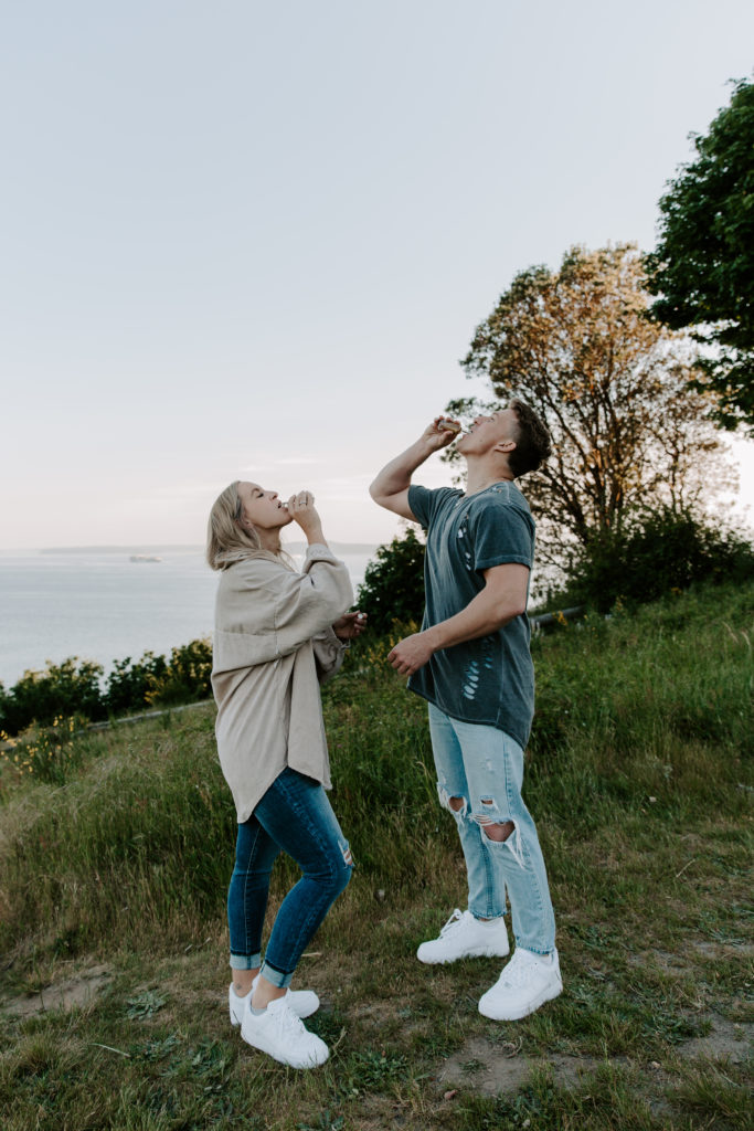 A couple taking shots at the beginning of their engagement photos at Discovery Park in Seattle
