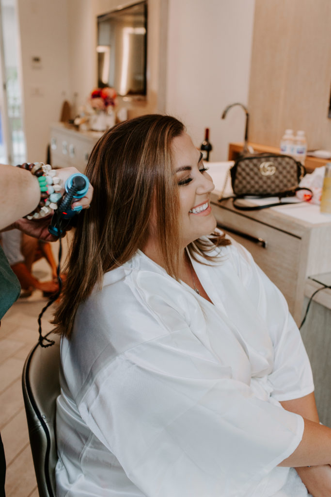 A woman smiling as she is getting her hair done for her key west elopement