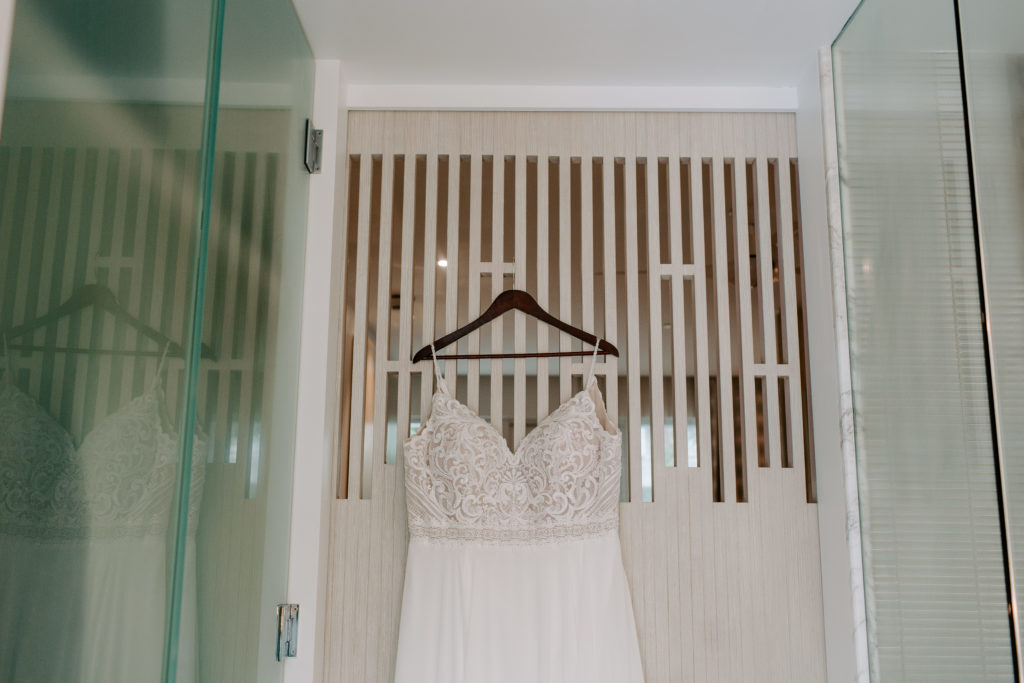 A lace wedding dress hanging on the back of a door at H20 Suites in Key West