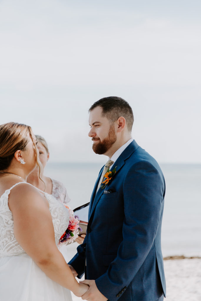 A man looking at his partner during their vows on smathers beach