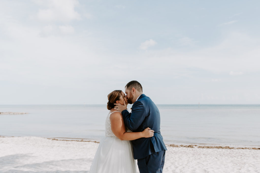 A couple sharing their first kiss during their Smathers Beach wedding ceremony