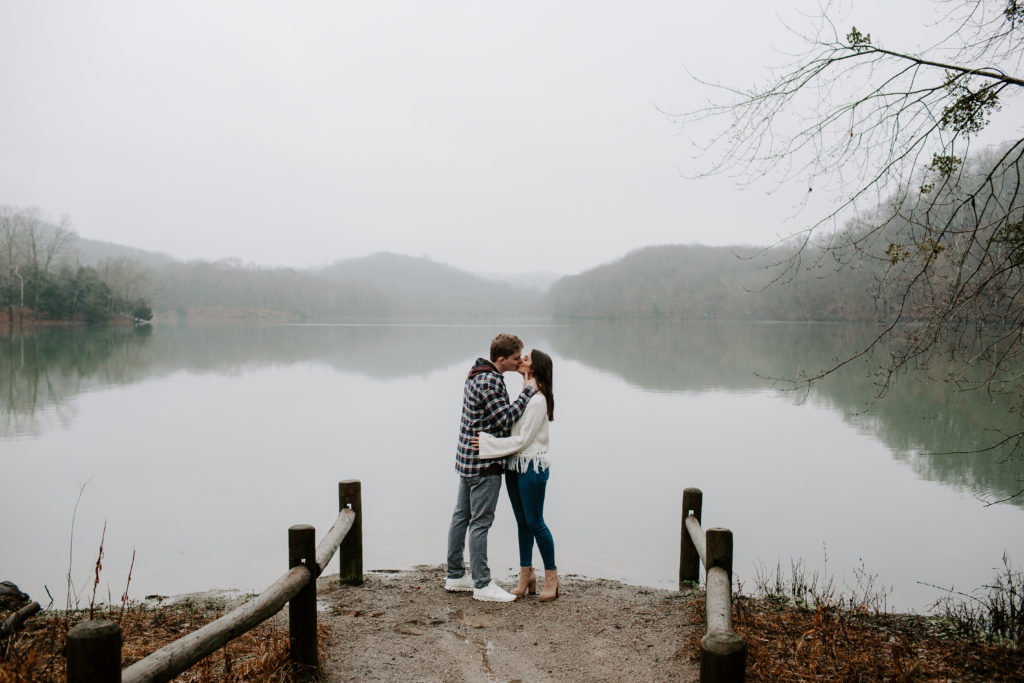 Man and his partner sharing a kiss as the waters edge during their Tennessee state park couple photos