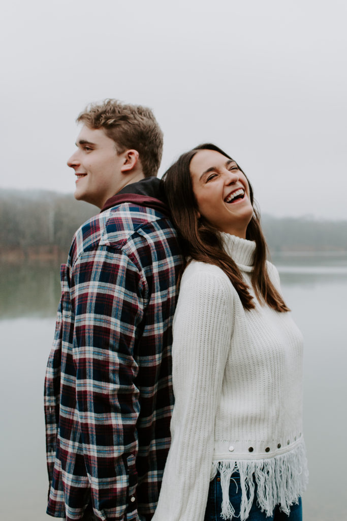 Woman leaning against her partner as they are holding hands and laughing during their Nashville engagement photos