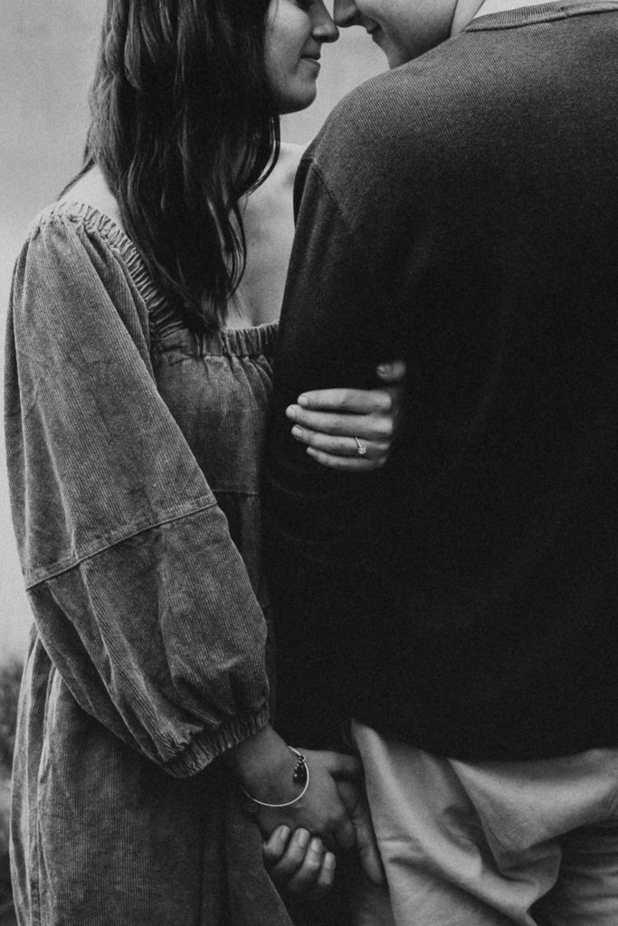 Couple leaning their heads together as they are holding each others hands during their Nashville couple photos