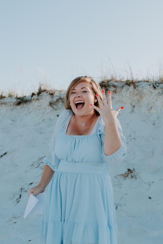 Woman very excited after getting engaged on a beach in Destin