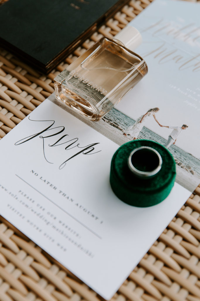 Wedding band sitting on top of ring holder on top of wedding RSVP